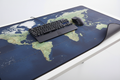 Imagen de producto estilo E-commerce de un Mousepad Gamer XL con diseño de mapa mundial.
Mousepad extra grande (90x40 cm) cubriendo gran parte del escritorio moderno y ordenado, con teclado y mouse gamer encima para mostrar la escala real.
Superficie textil suave con impresión detallada del mapa mundial, colores sobrios y elegantes.
Bordes cosidos visibles, acabado de alta calidad.
Base de goma antideslizante, ligeramente levantada en un esquina para mostrar el grosor de 3mm.
Sensación de producto premium. 